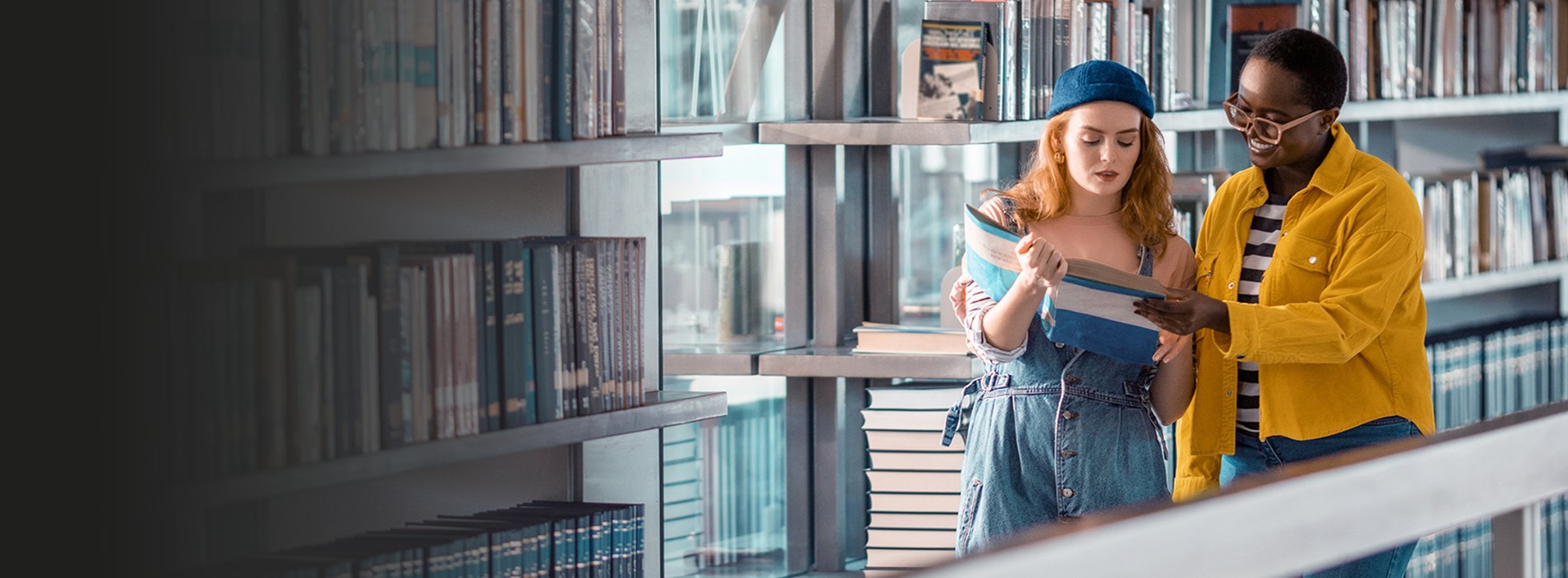 Two students in a library studyng